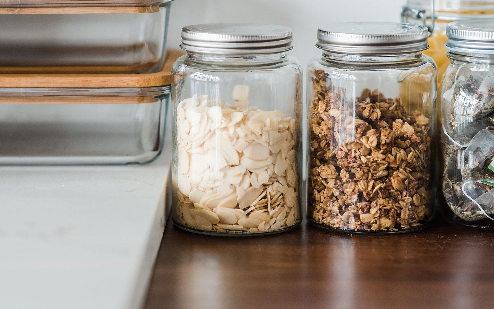 Glass food storage containers on a pale kitchen counter in daylight