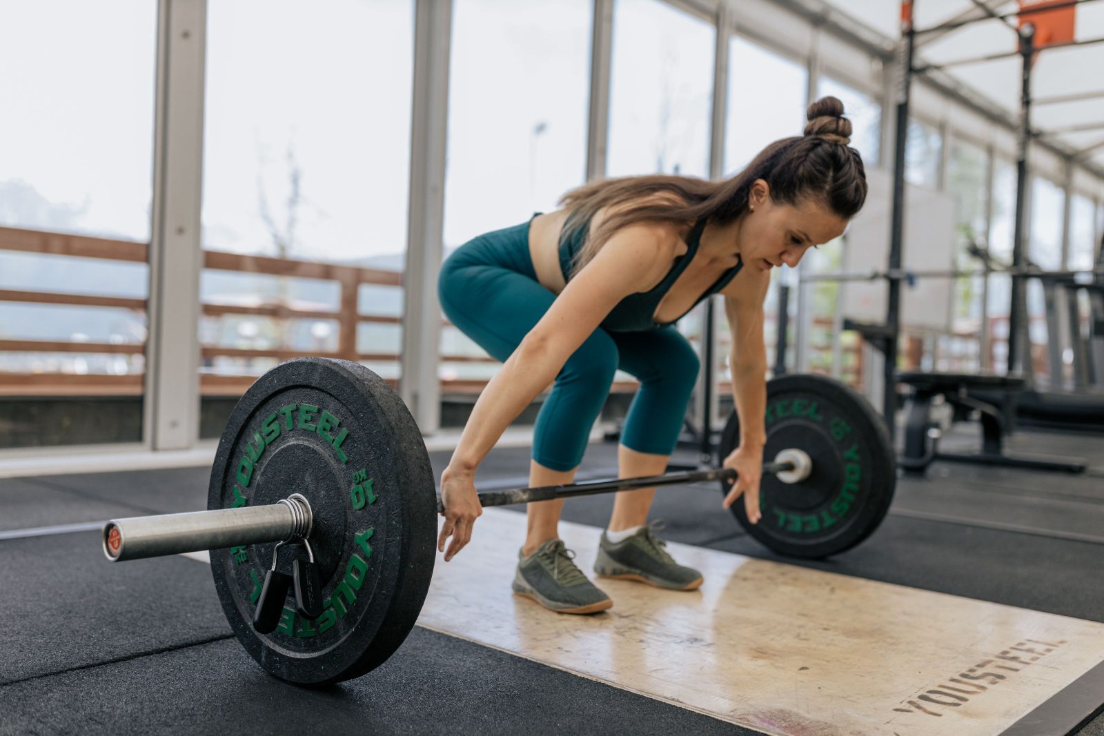 A woman lifting a loaded barbell during a strength training session