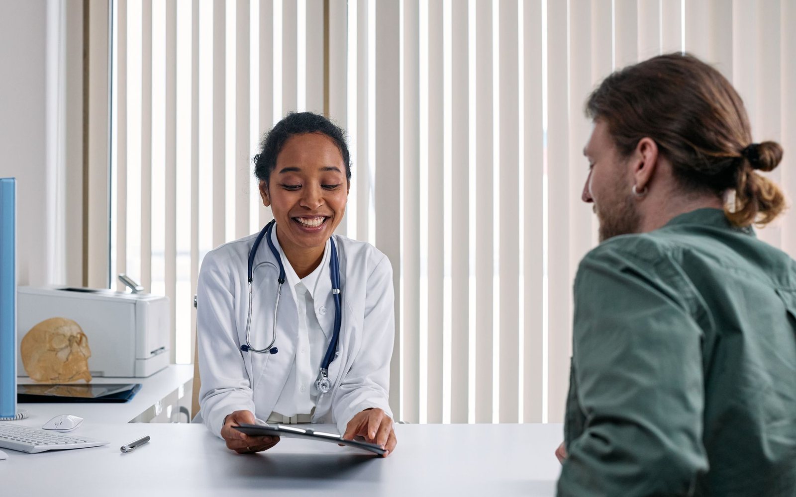 A clinician and patient in conversation in a bright consulting room